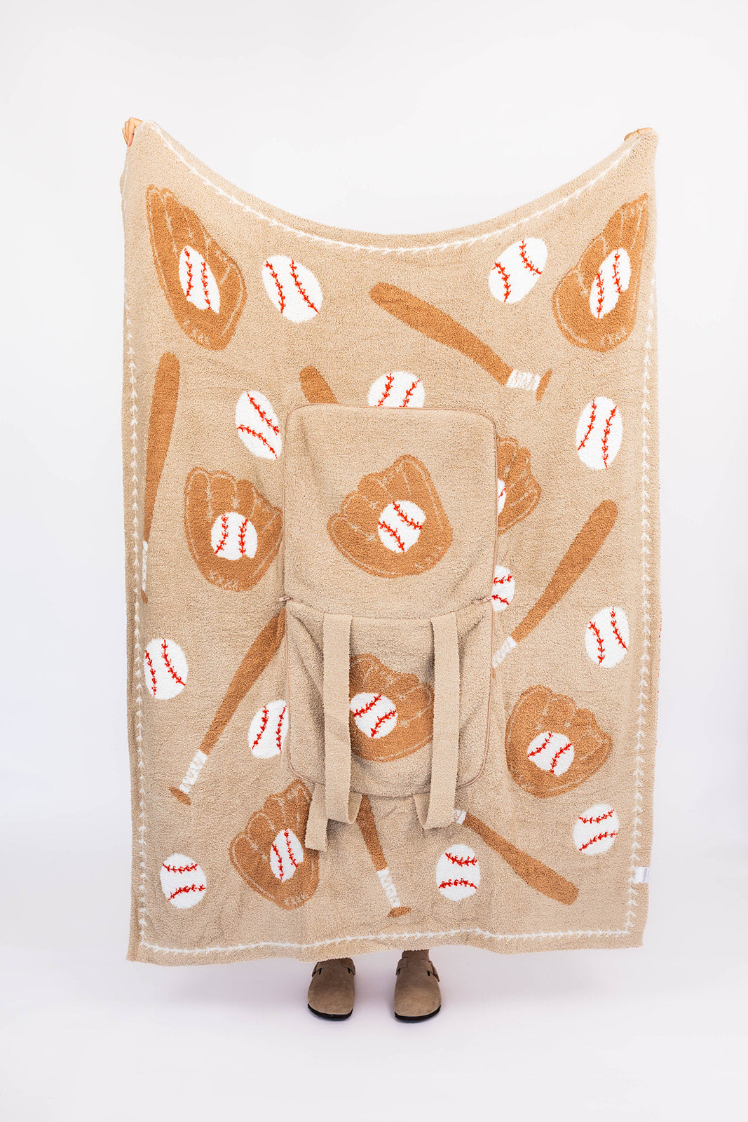 Beige blanket with baseball-themed pattern on a white background