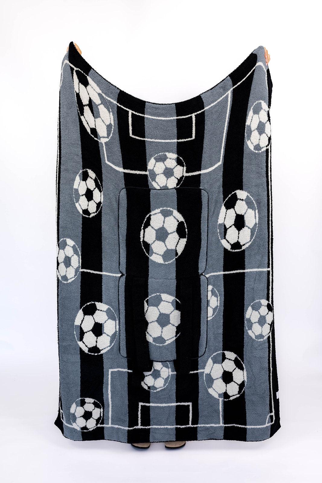 Black and grey patterned blanket with soccer ball design on a white background