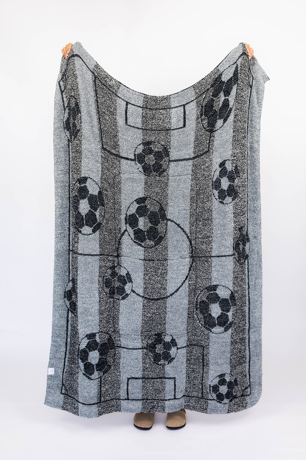 Gray blanket with soccer ball pattern on a white background
