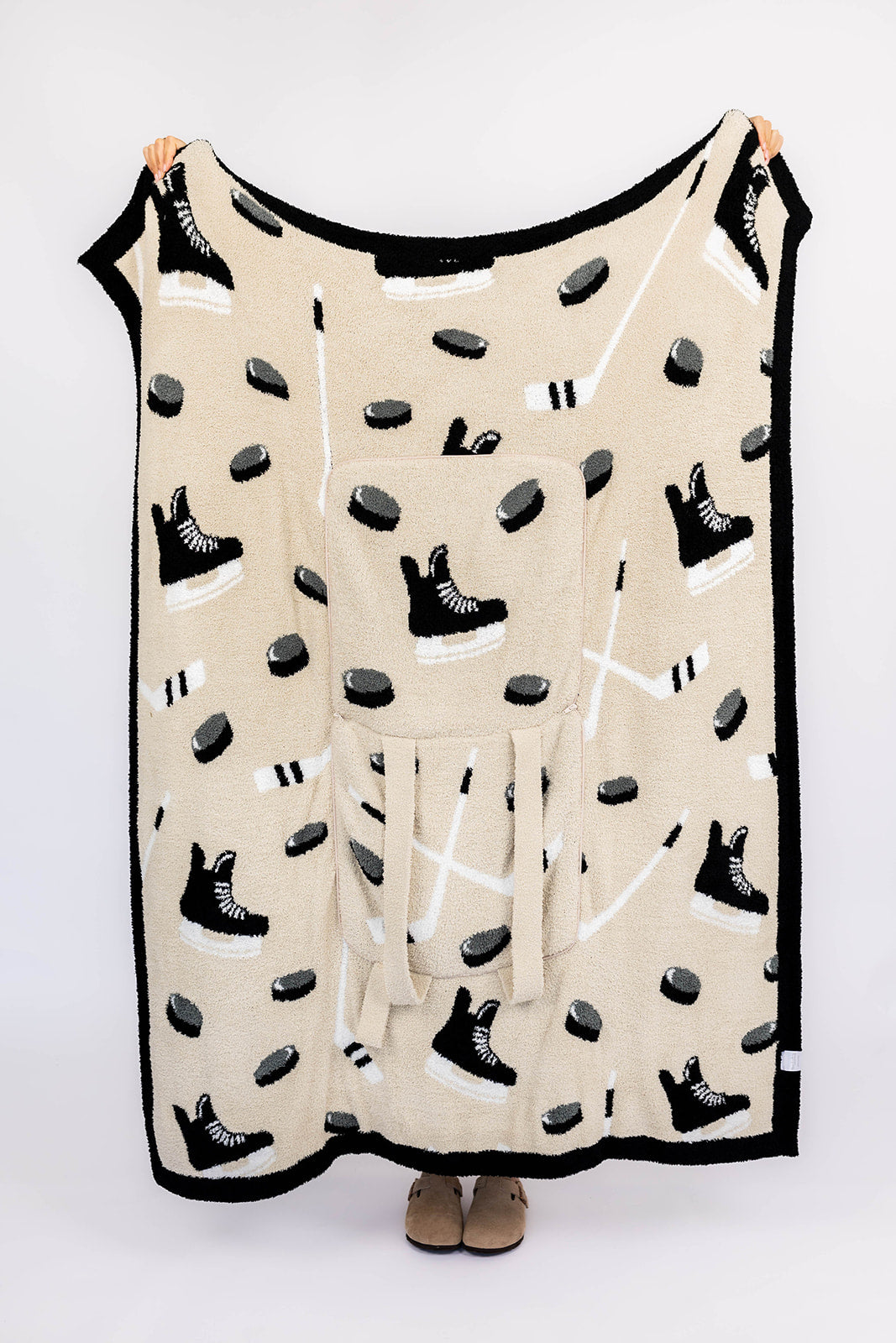Beige blanket with black and white hockey pattern on a white background