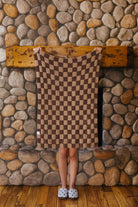 Brown check kids blanket held open to show the checkerboard pattern.