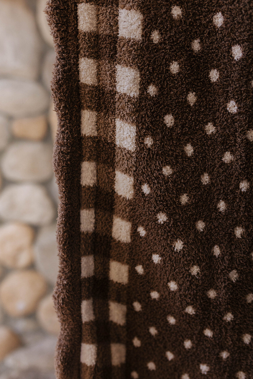 Close view of the gingham border and polka dot texture on the kids blanket.