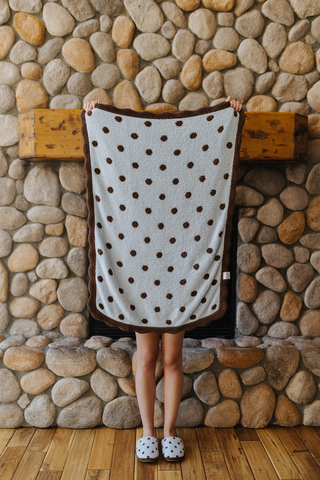 Light blue baby blanket with brown polka dots held open.