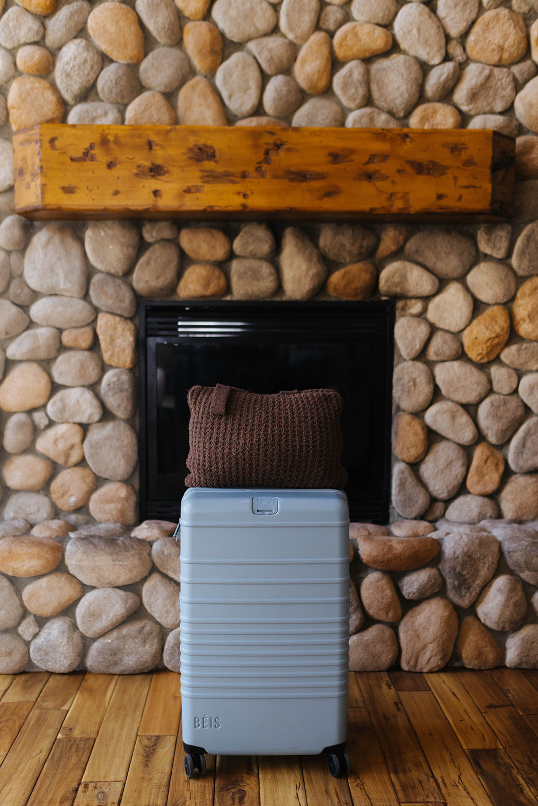 Folded brown waffle quillow resting on a suitcase.