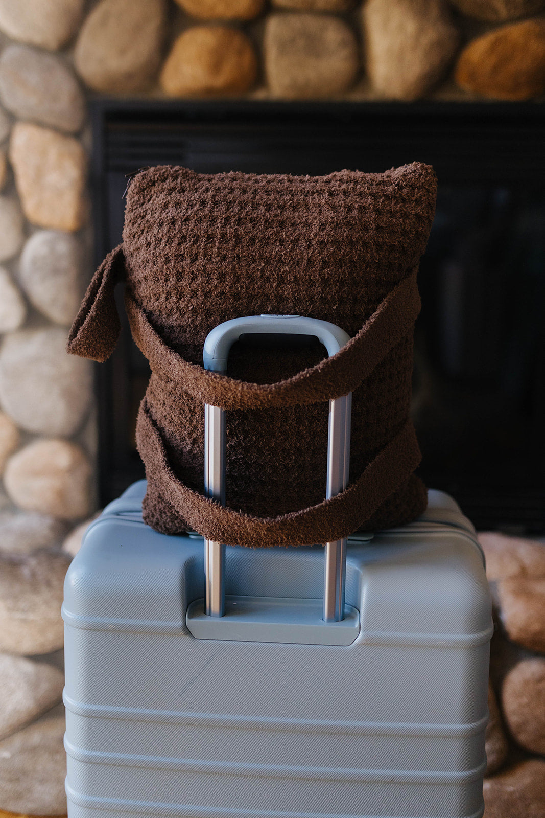 Close view of the brown waffle quillow backpack straps on a suitcase.