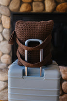 Close view of the brown waffle quillow backpack straps on a suitcase.