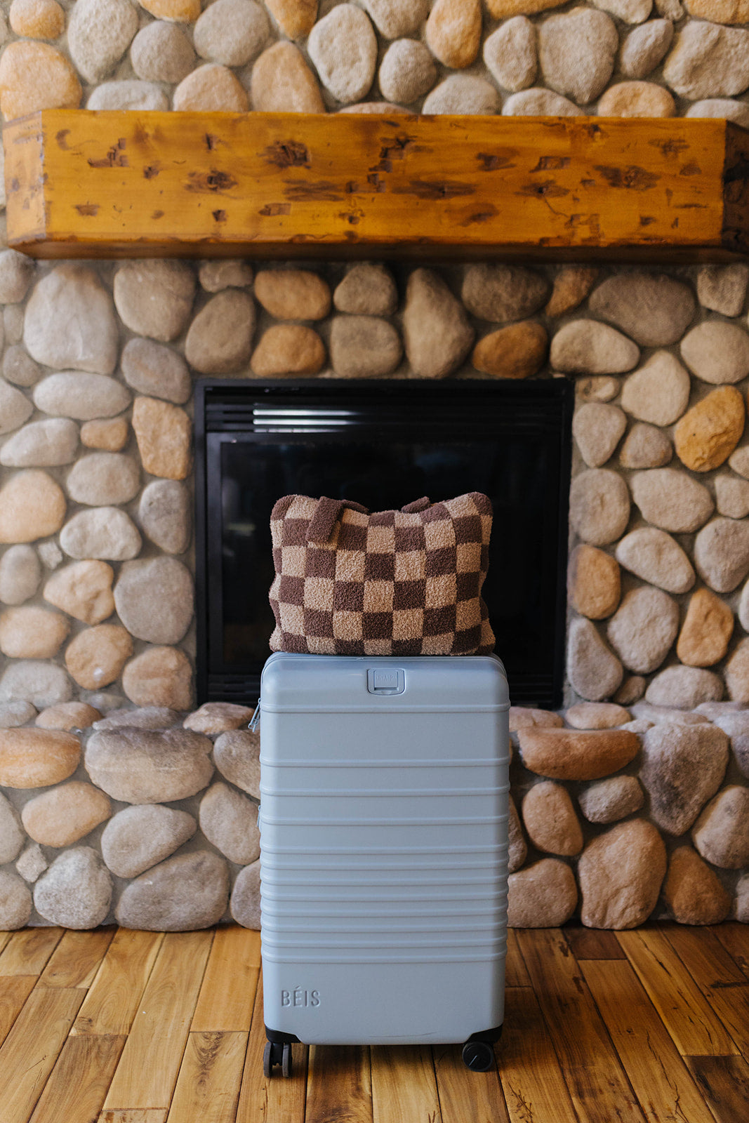 Brown check quillow folded on a suitcase.