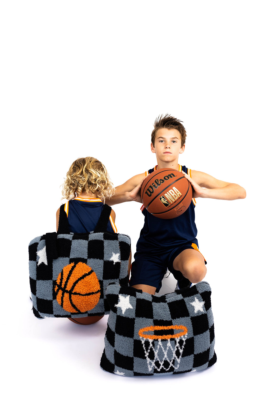 Two children playing with basketballs with basketball quillows a white background