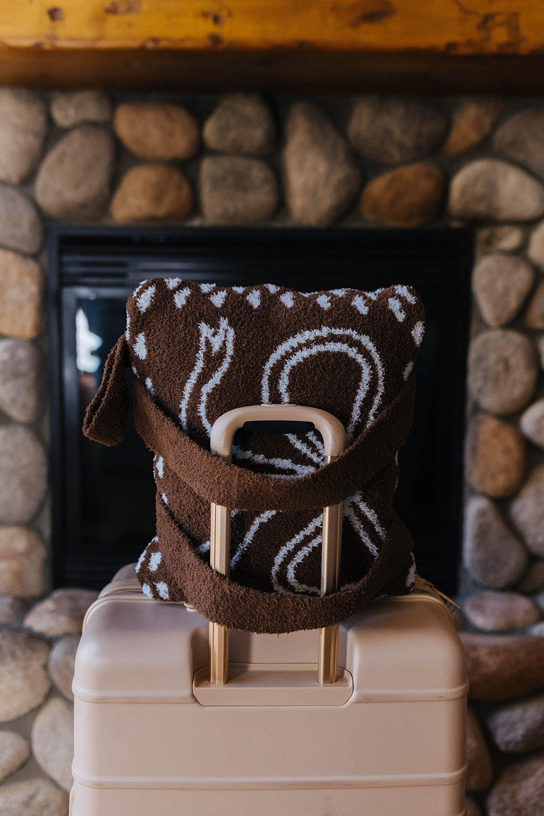 Folded bow quillow with backpack straps resting on a suitcase.