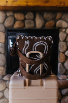 Folded bow quillow with backpack straps resting on a suitcase.