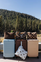 Four folded quillows displayed with suitcases outdoors.