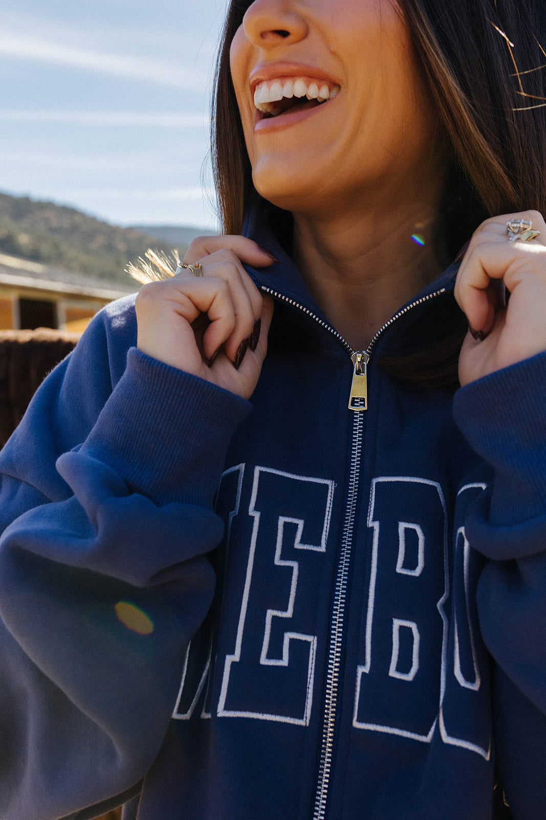 Close view of the blue Homebody zip sweatshirt collar and lettering.