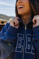 Close view of the blue Homebody zip sweatshirt collar and lettering.