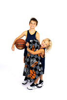 Two children in basketball-themed outfits with a blanket, on a white background