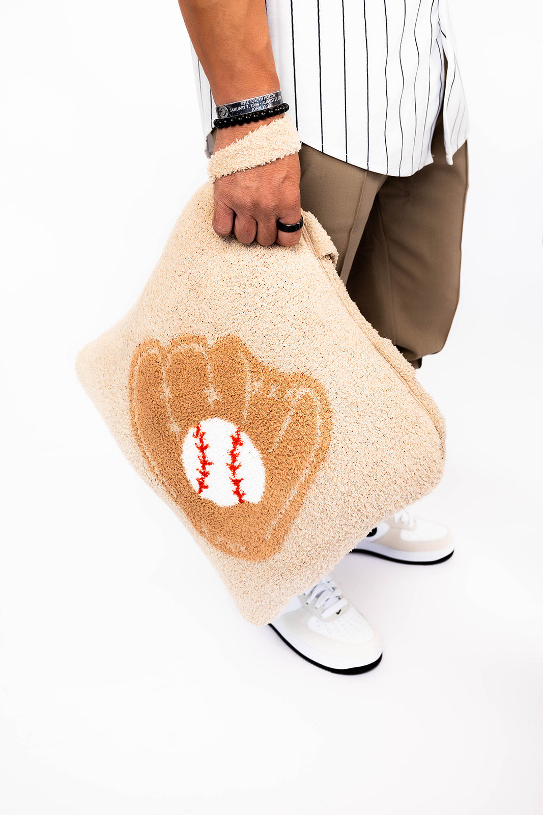 Person holding a quillow with a baseball glove design on a white background