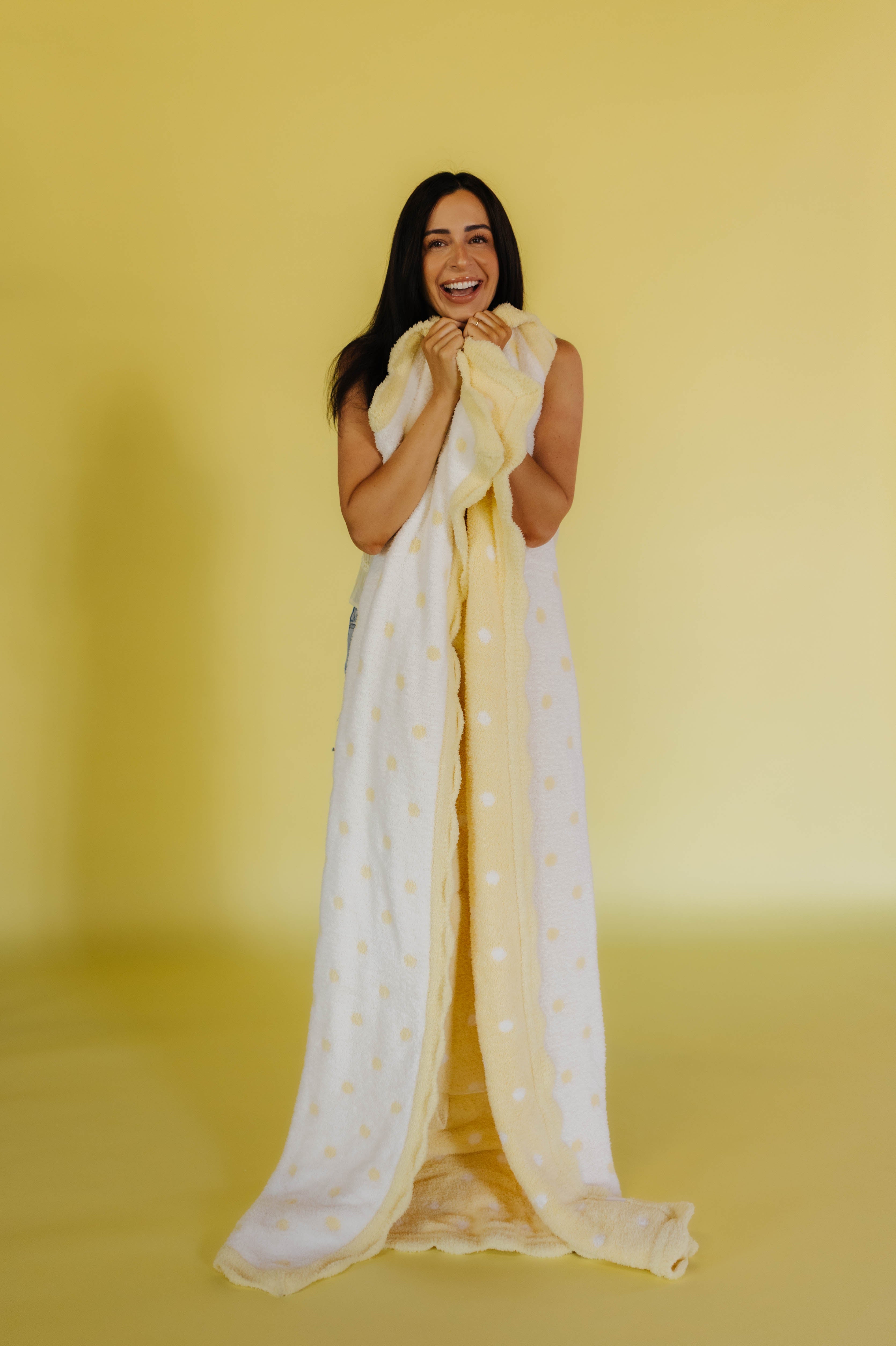 holding the white and yellow polka dot quillow