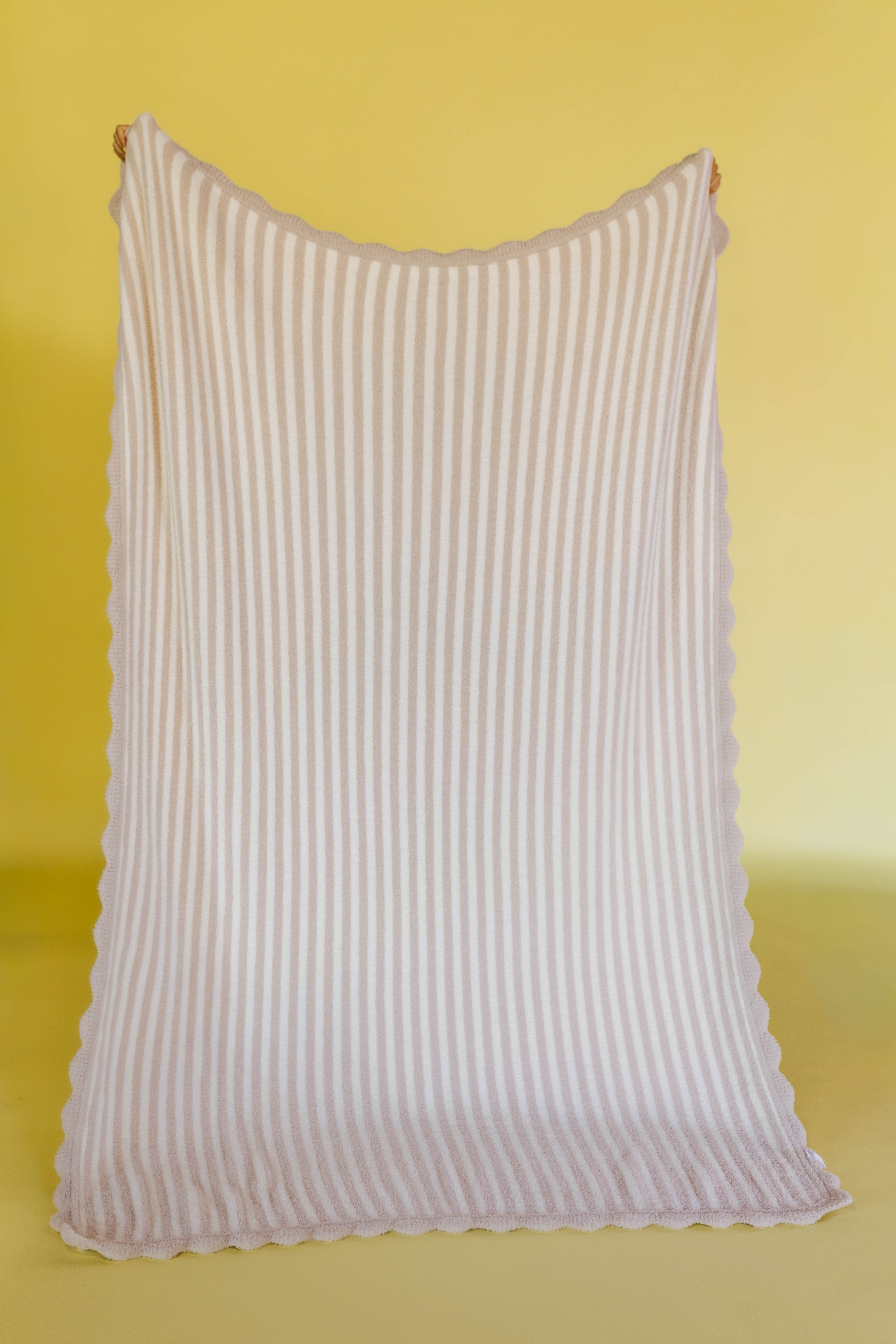 Pinstripe blanket with scallop detailing on a yellow background