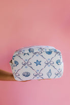 Cosmetic bag with shell and star pattern on a pink background
