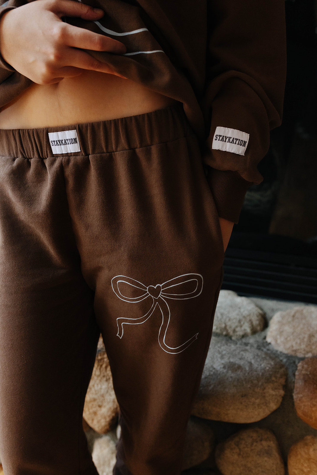 Close view of the brown bow sweatpants waistband.