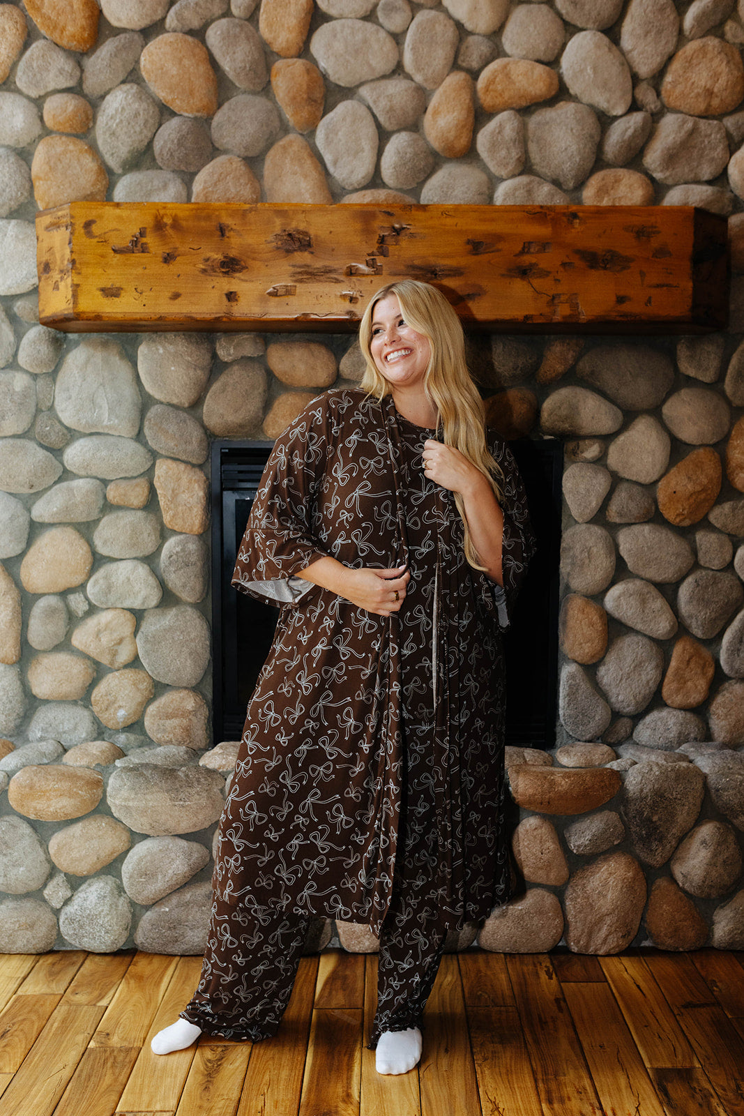 Full length front view of the brown bow print robe tied at the waist over matching pajamas.