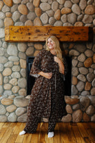 Full length front view of the brown bow print robe tied at the waist over matching pajamas.