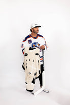 Person wearing a hockey jersey and holding a hockey stick and hockey blanket on a white background