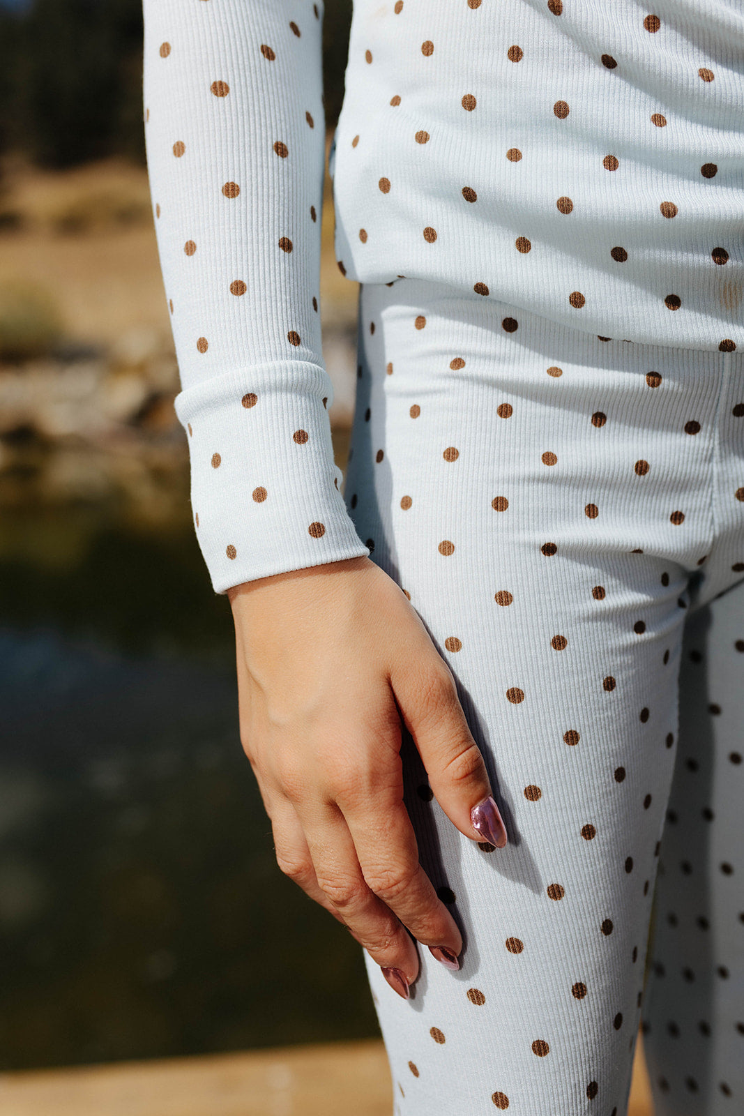 Close view of the kid blue and brown polka dot pajama waistband and sleeve.