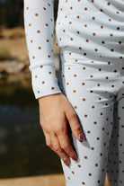 Close view of the kid blue and brown polka dot pajama waistband and sleeve.