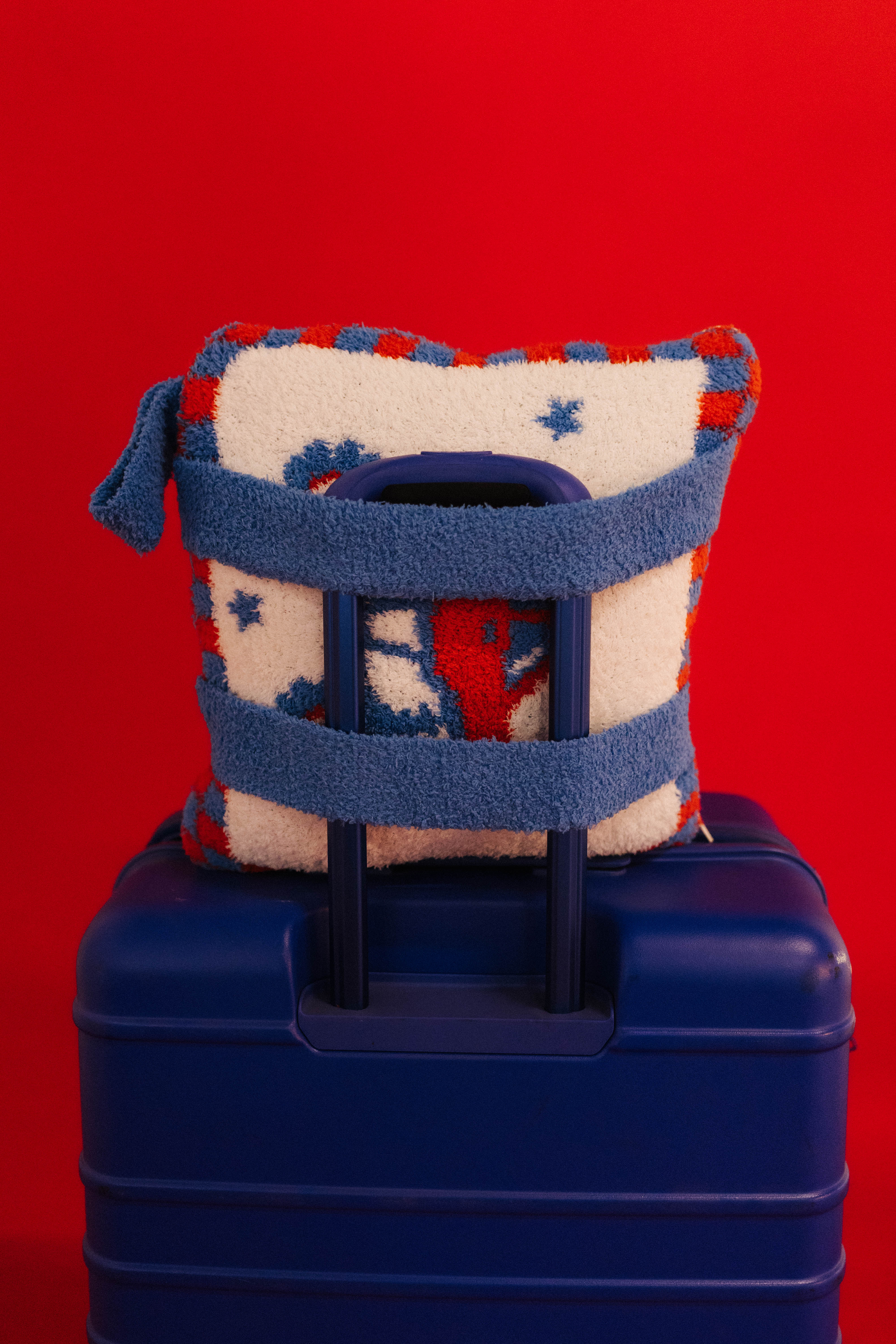 monster truck quillow on blue luggage showing the backpack straps