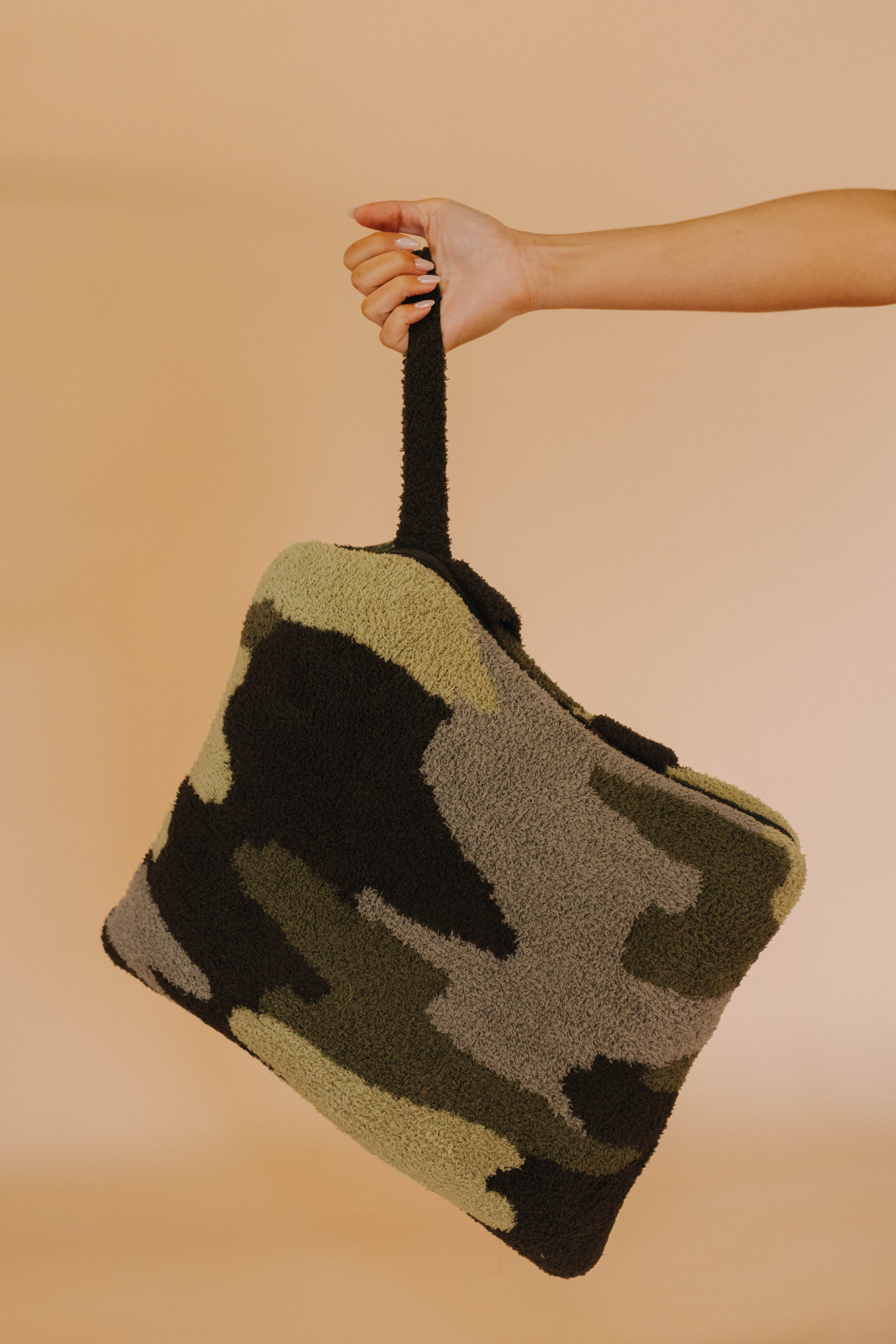 holding the quillow by it's wristlet in front of cream background