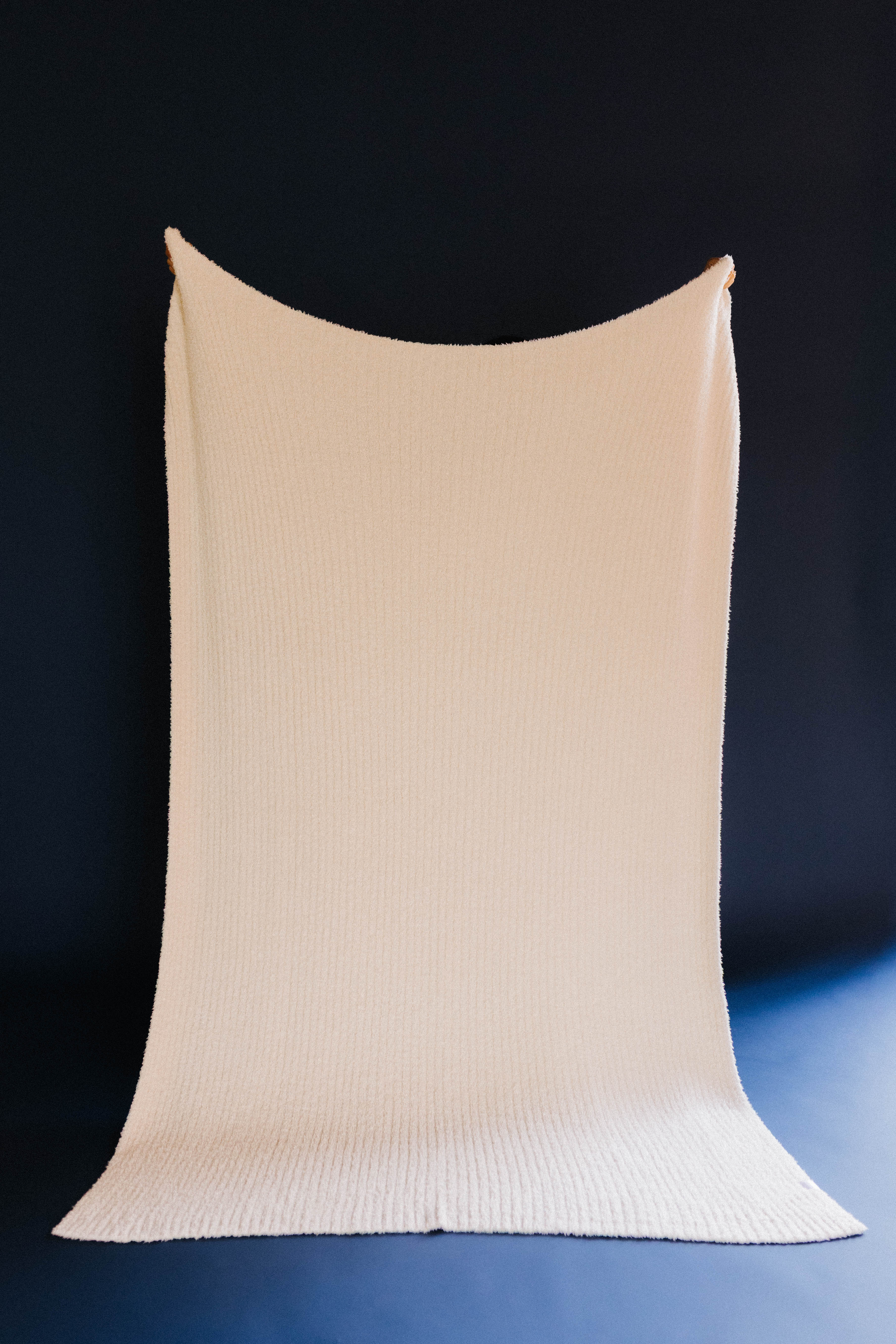 cream ribbed blanket on dark blue background