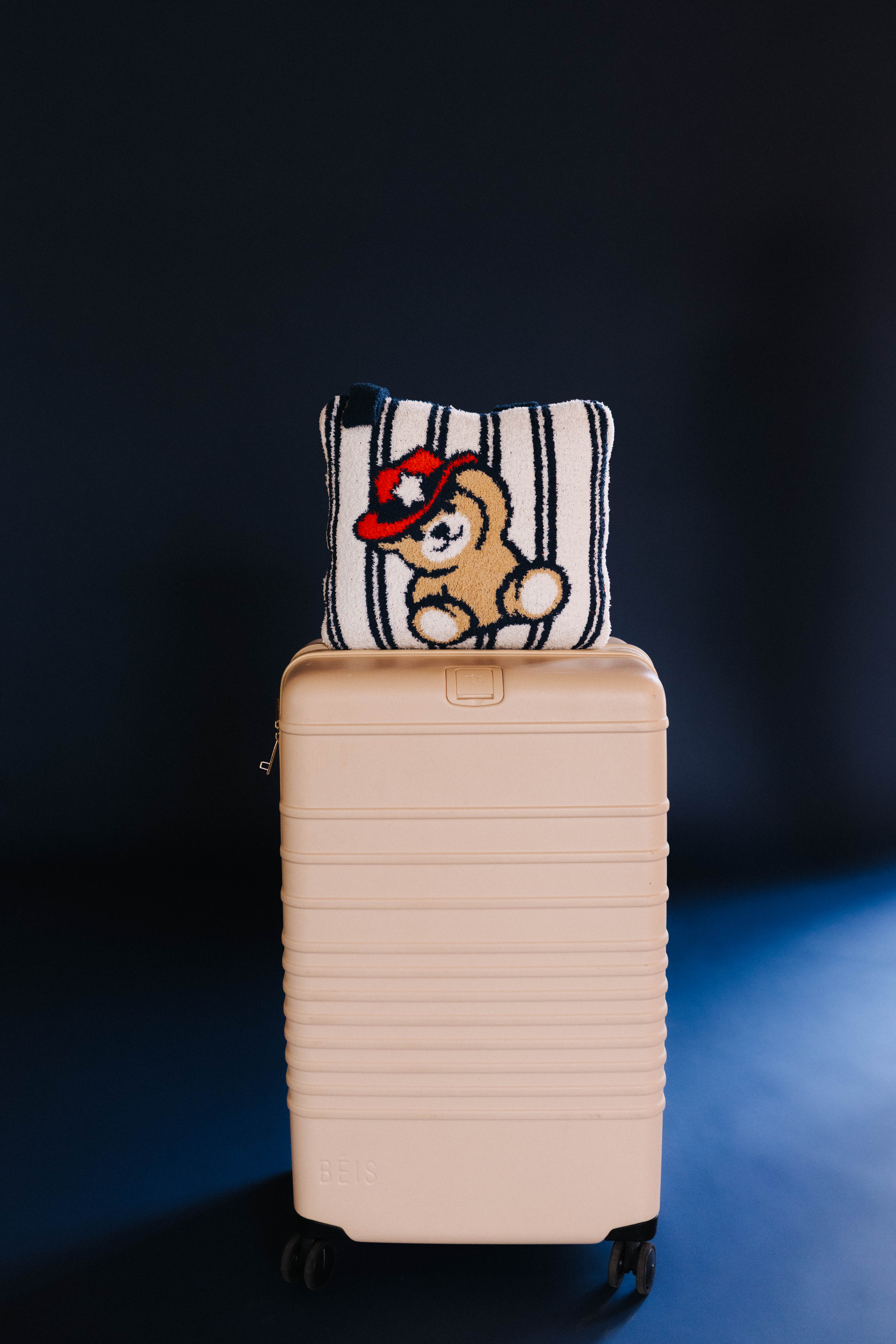 showing the teddy quillow front on top of the suitcase