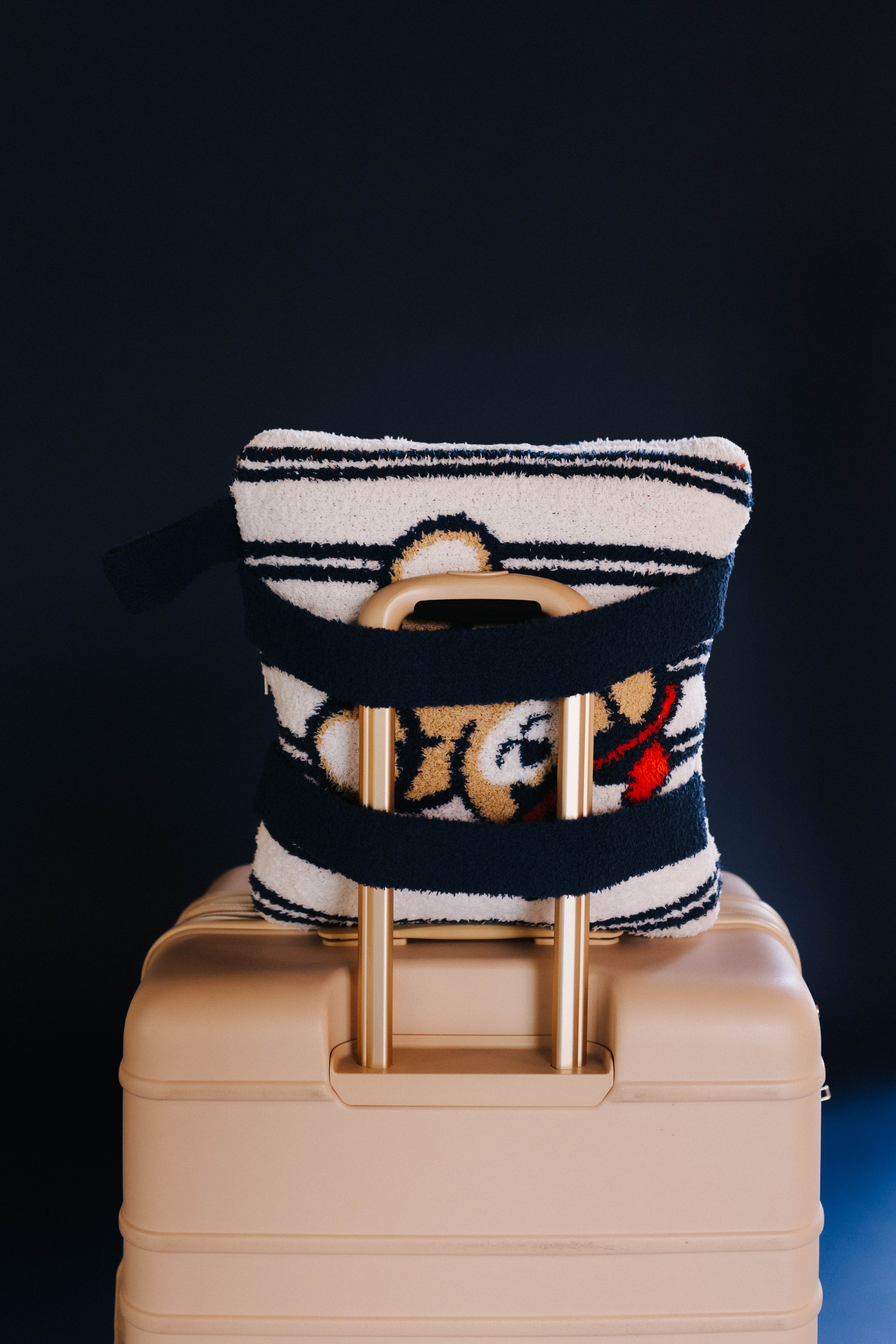 showing the quillow on top of the suitcase with the back side backpack straps