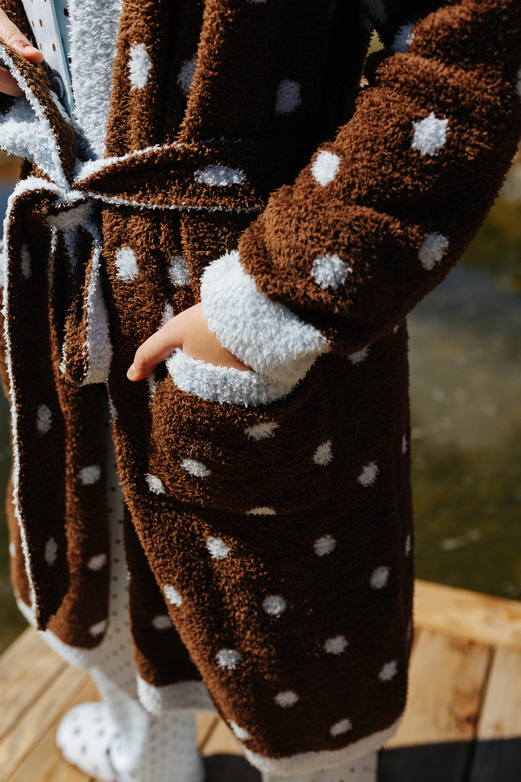Close view of the brown polka dot robe tied at the waist.