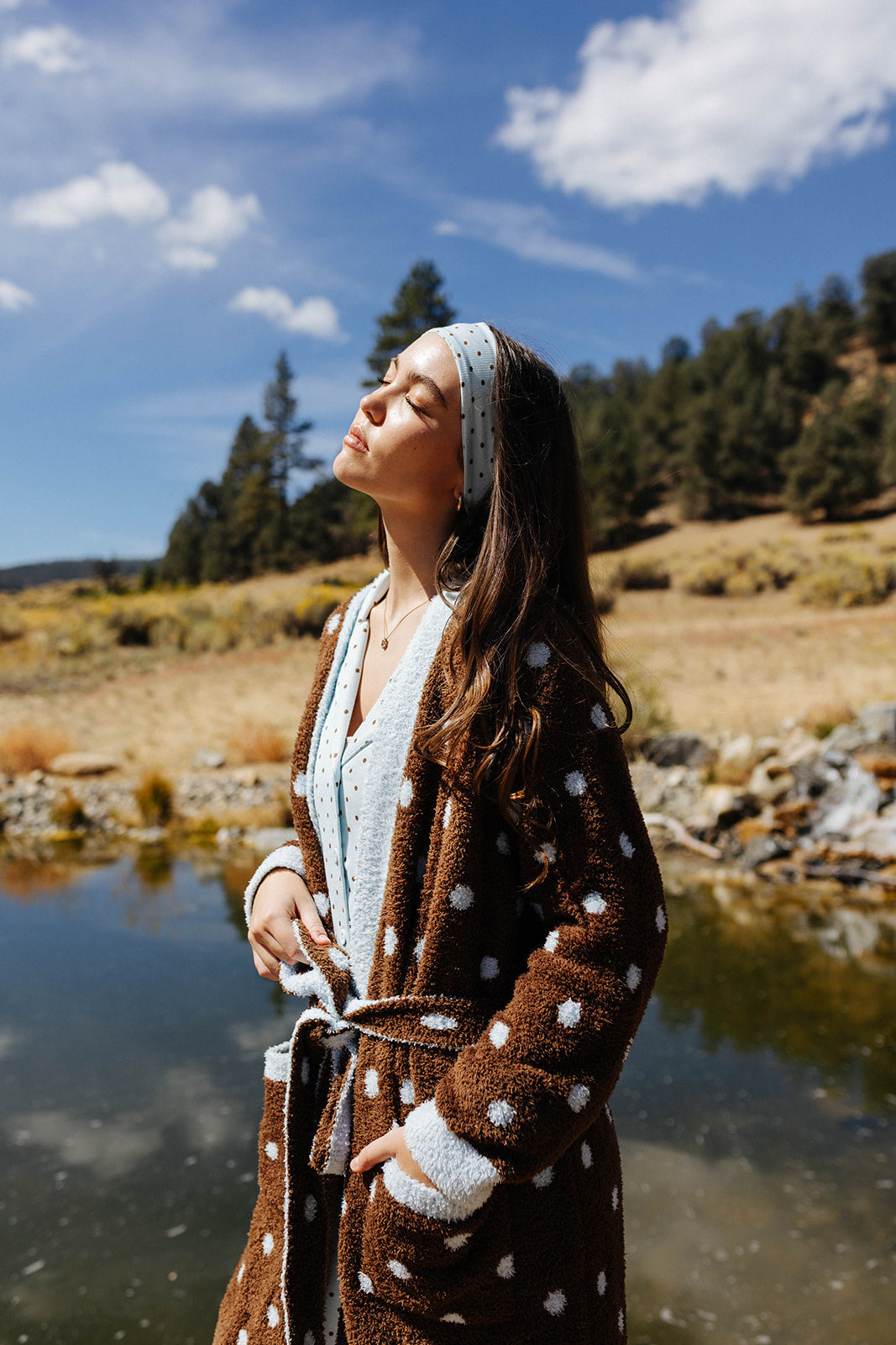 Model wearing the brown robe with blue polka dots over light blue pajamas.