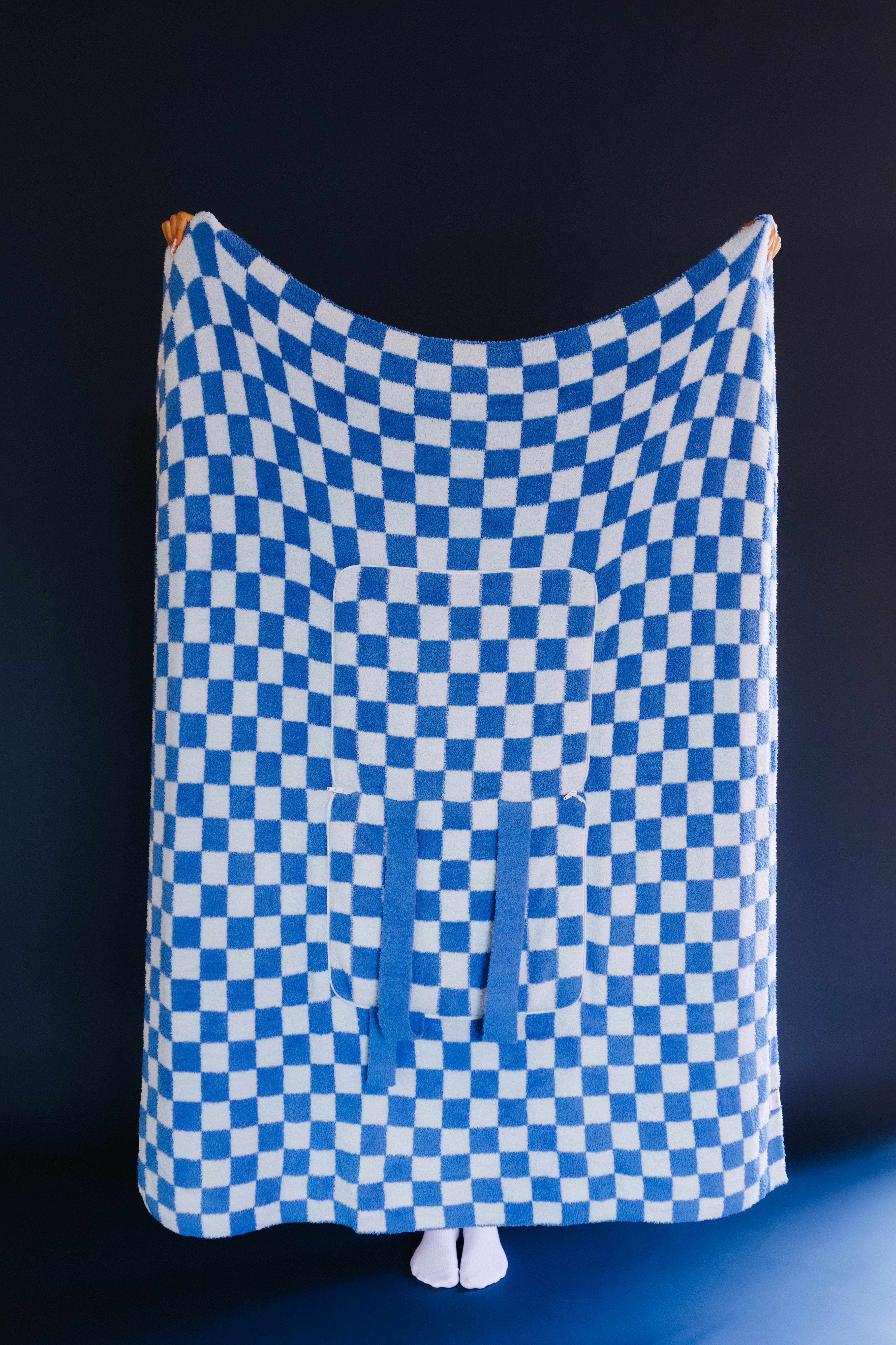 full front of blue check quillow being held up