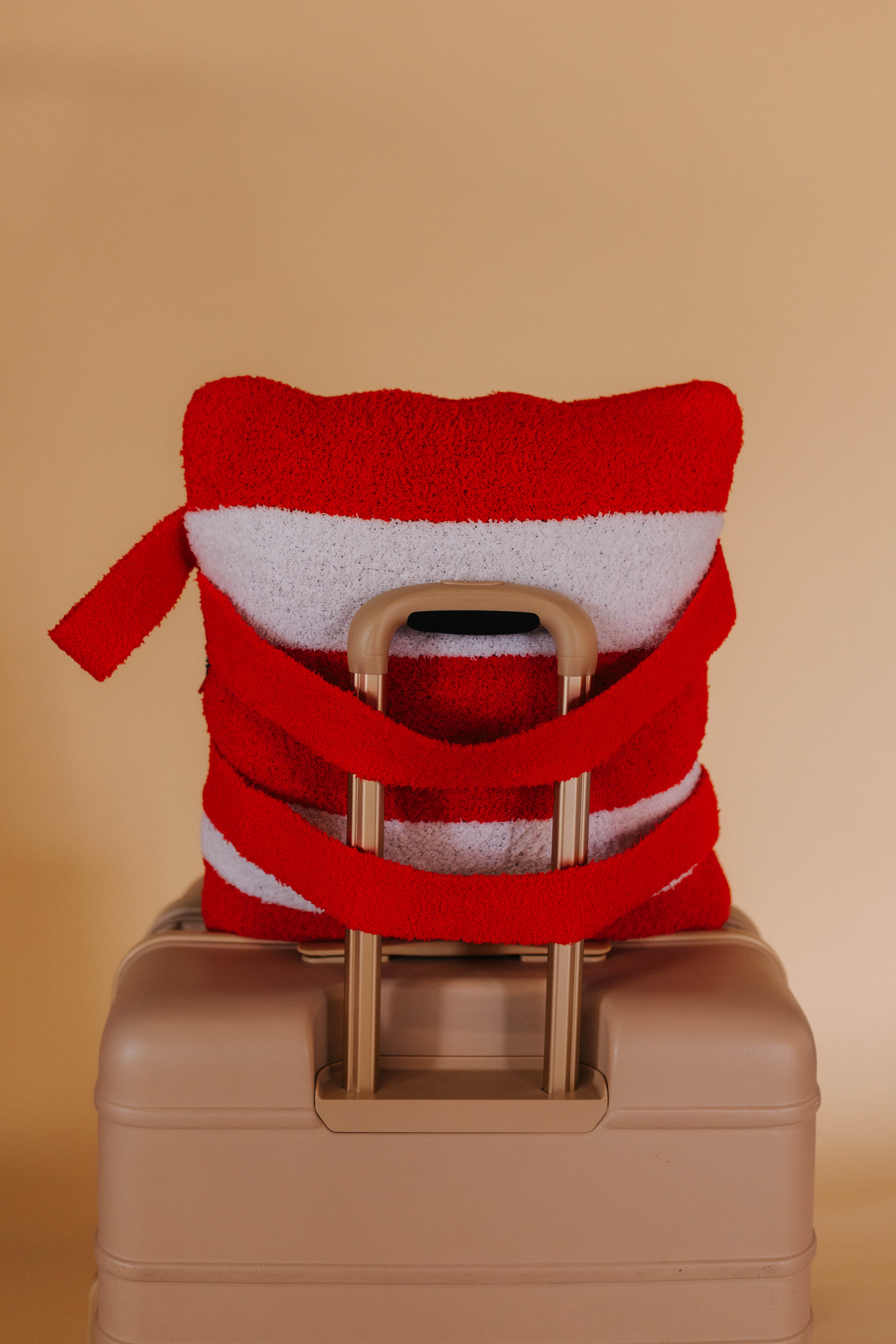 back of quillow on suitcase showing the backpack straps around the handle