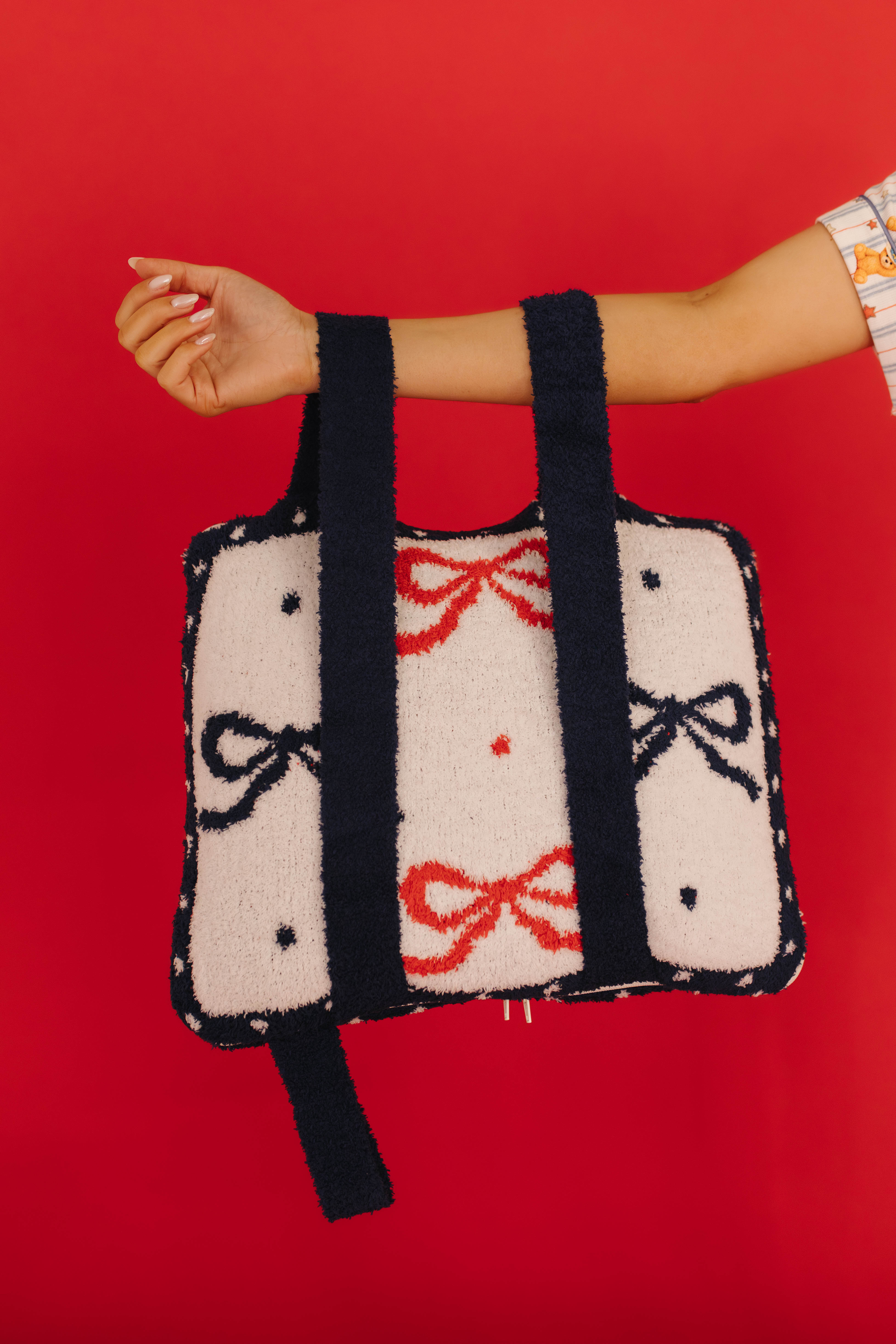 showing hand holding the backpack side of the quillow 