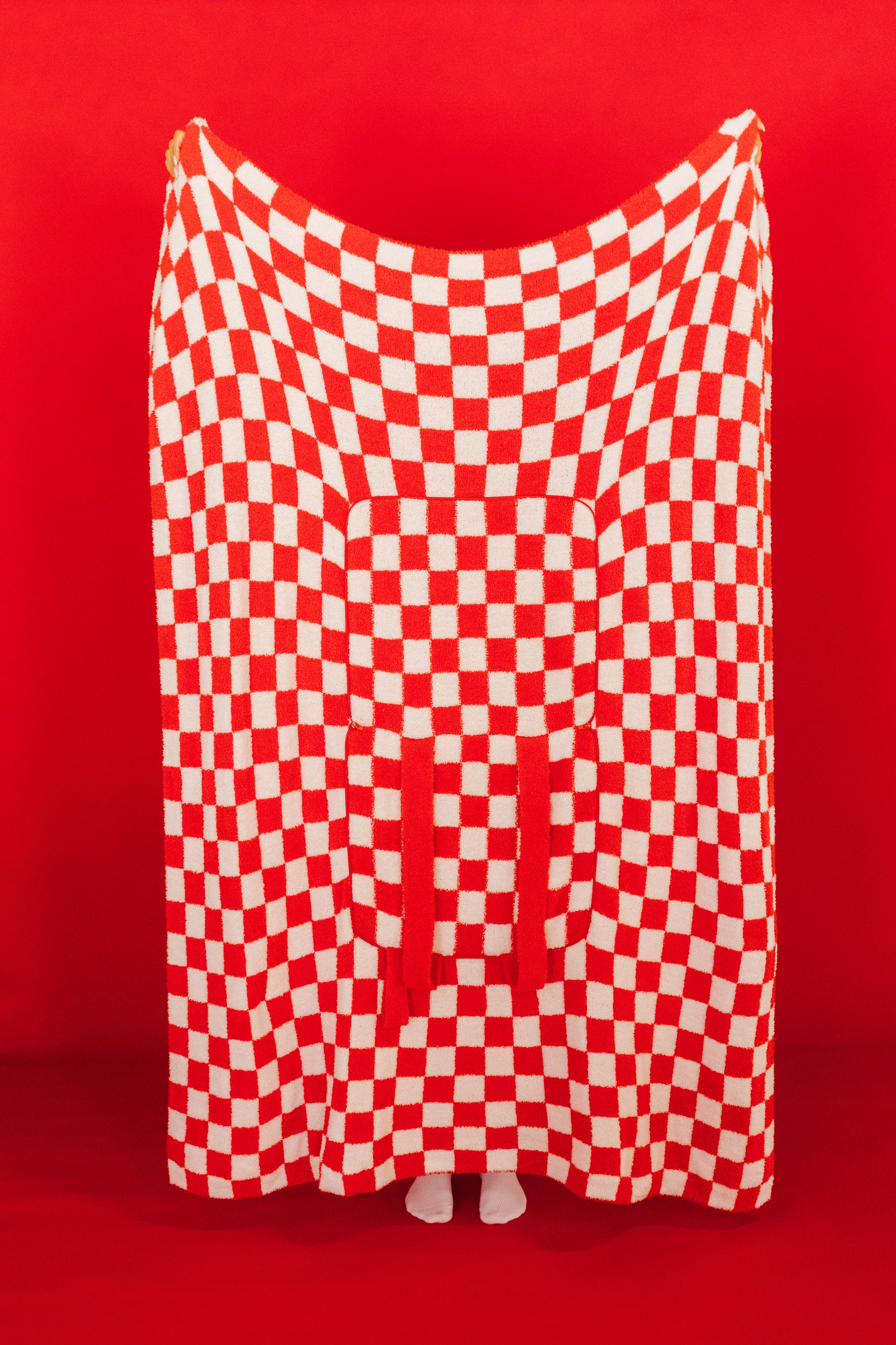 red check quillow being fully held up in front of red background