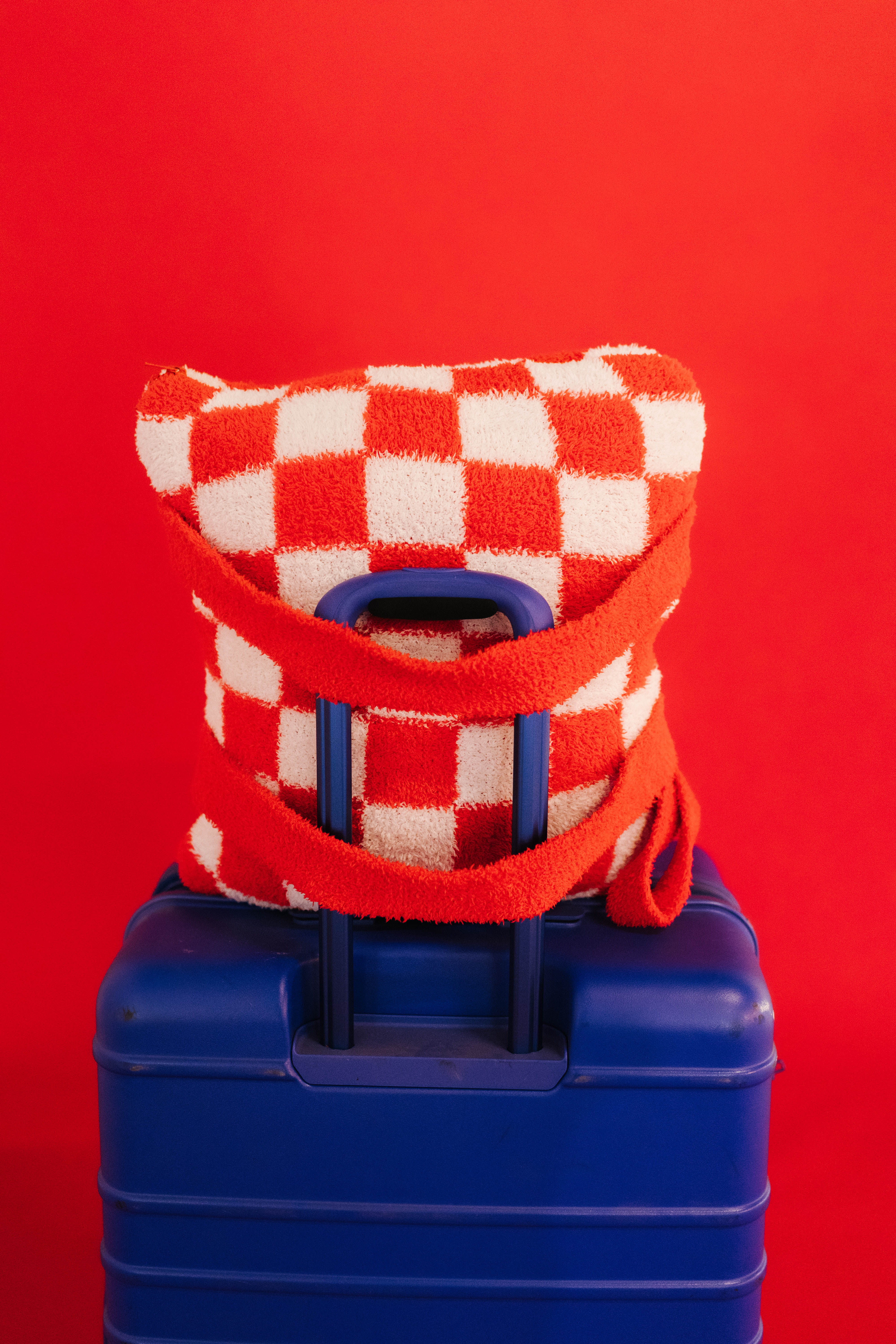quillow being held by the backpack straps on the suitcase handle