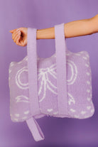 purple bow quillow being held by the backapck straps