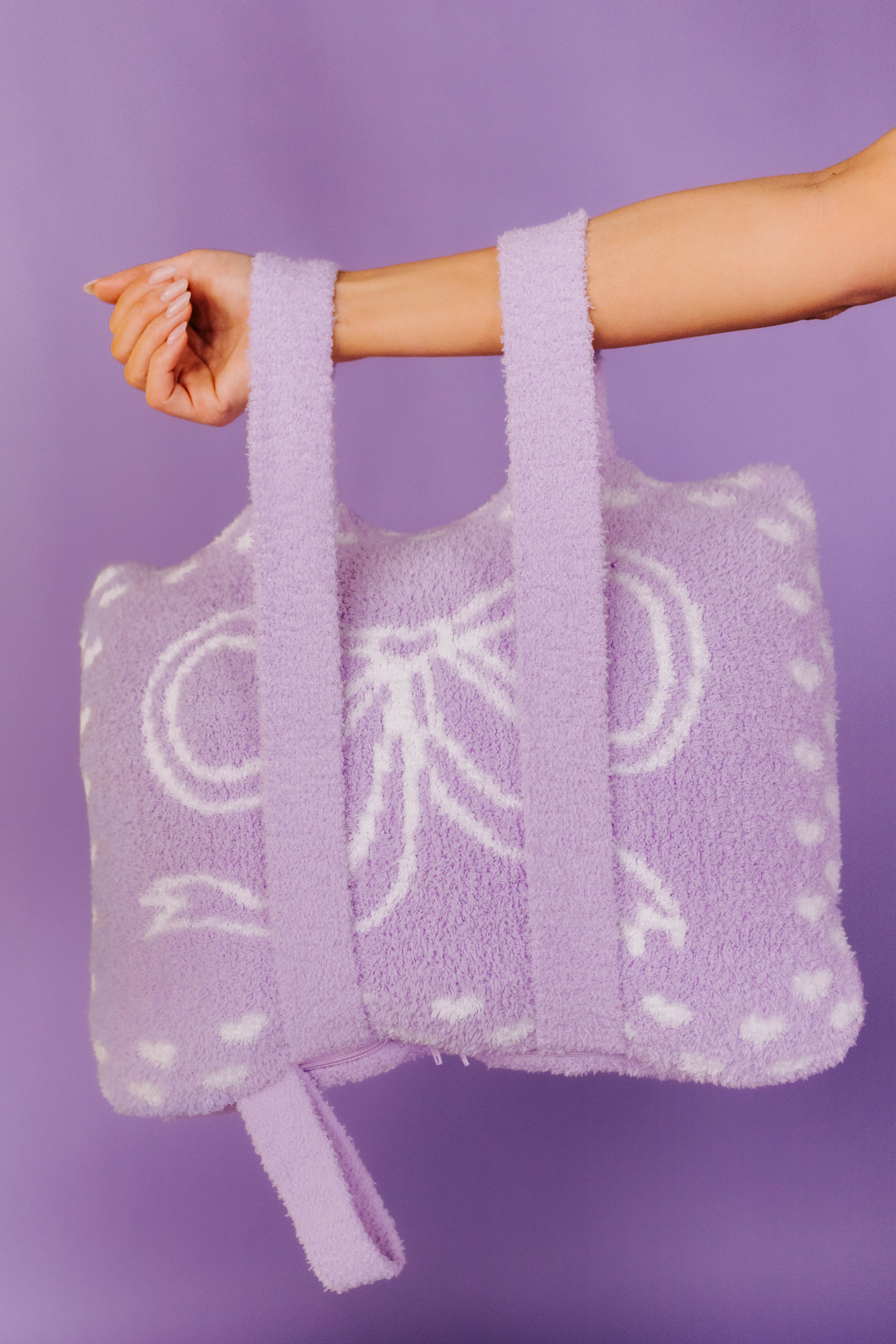 purple bow quillow being held by the backapck straps