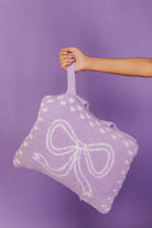 hand holding the purple bow quillow