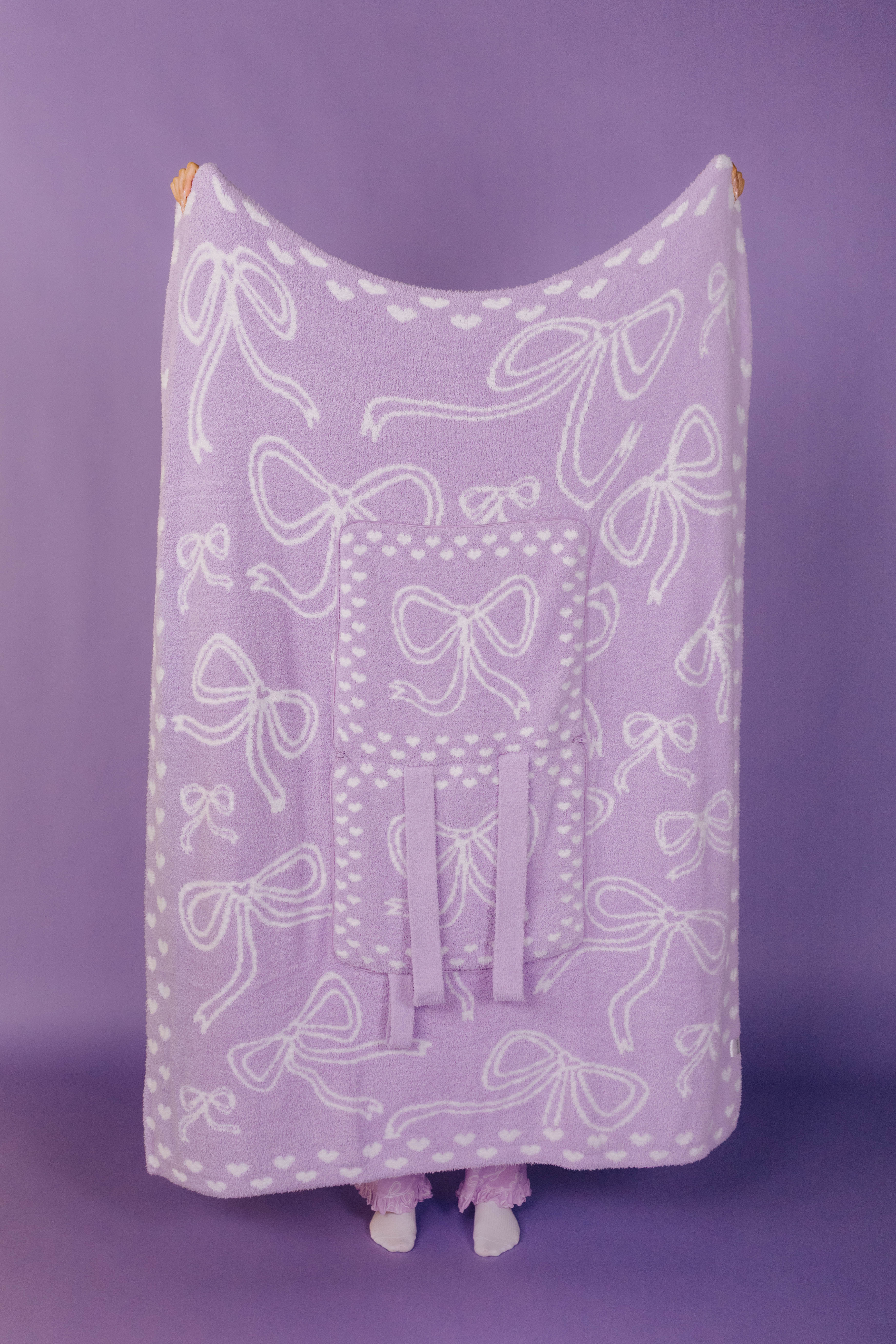 Lavender blanket with white bow pattern on a purple background