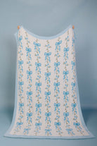 full front of the blue bow blanket being held up with a blue background