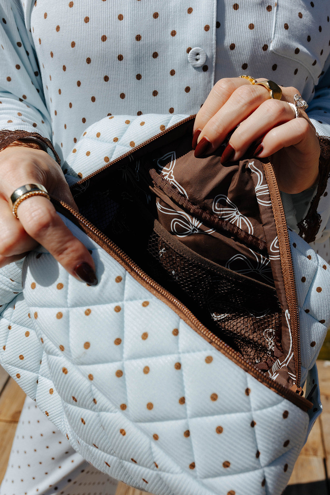 Open light blue and brown polka dot cosmetic bag showing the lining.