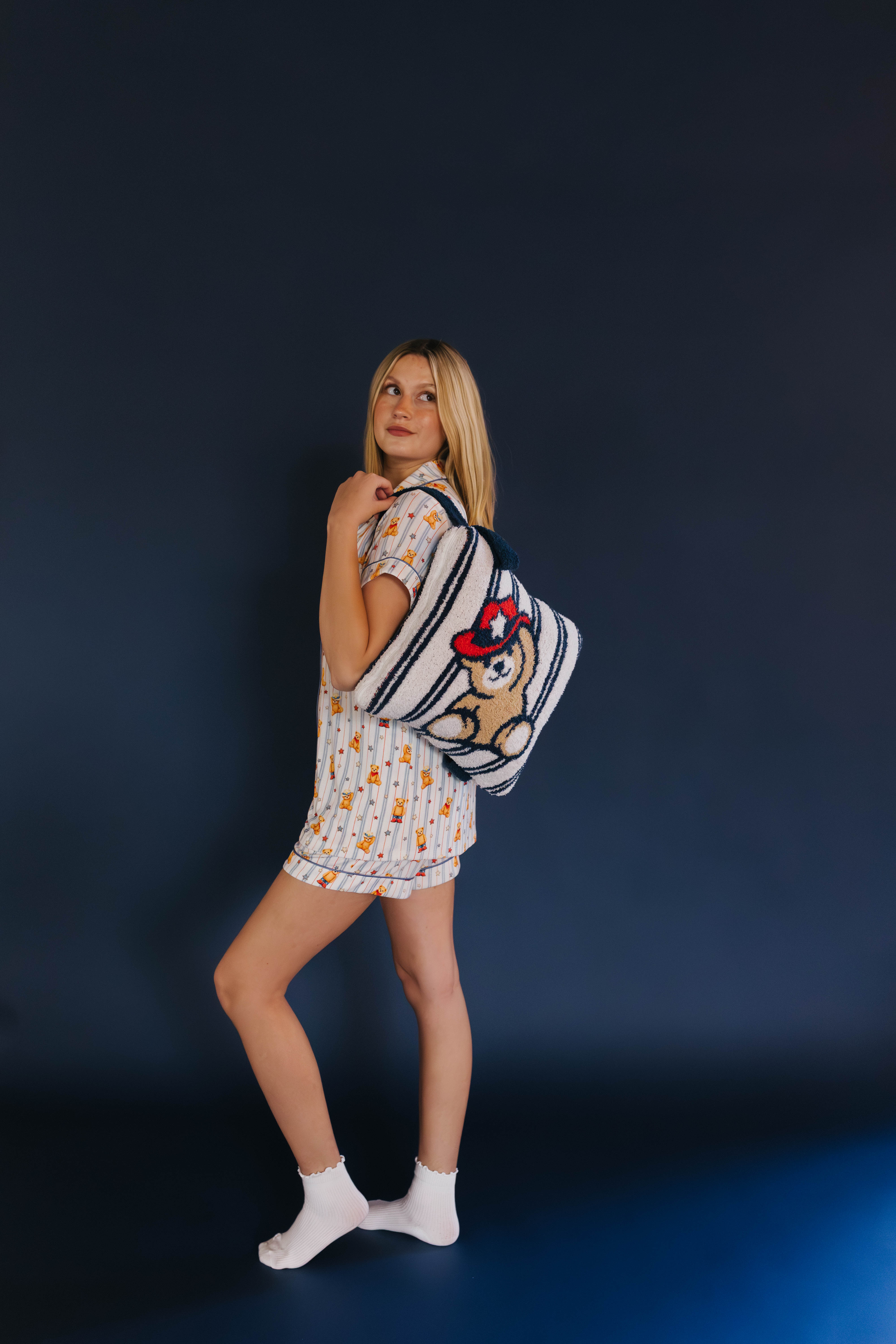 girl holding the quillow by the backpack strap on her back