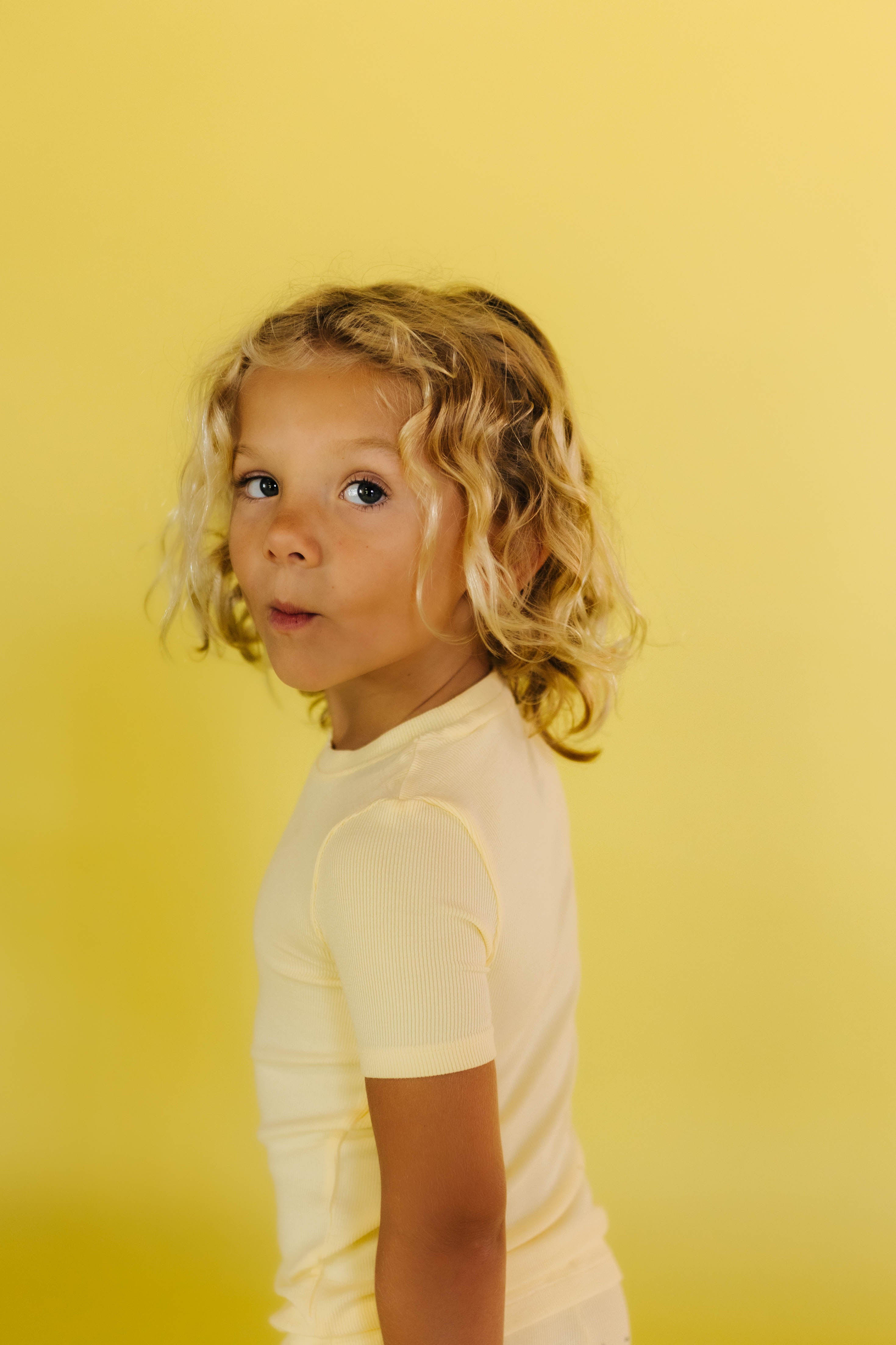 Kampers looking back at the camera in his yellow pjs and yellow background