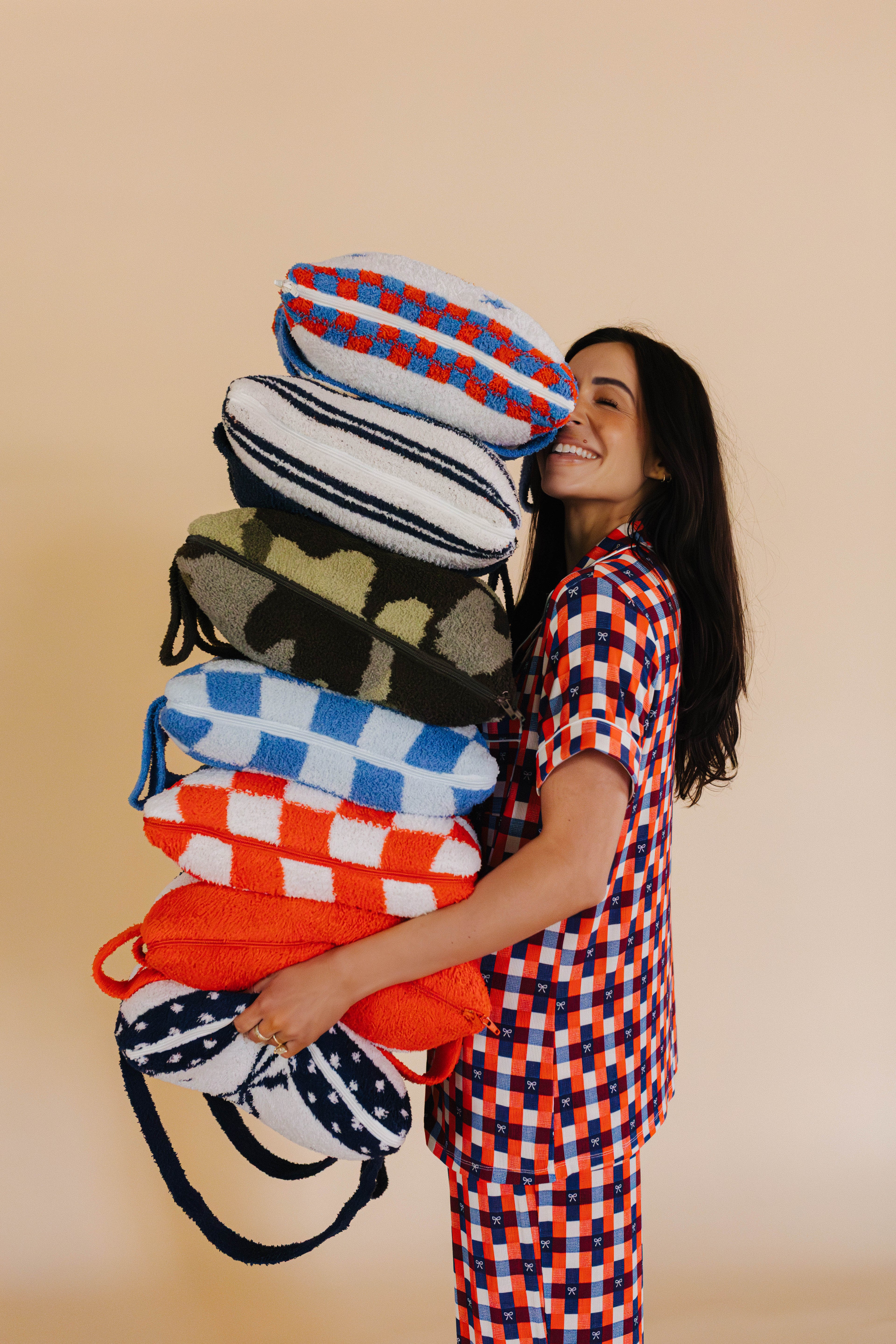 holding a stack of 7 quillows 