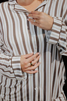 Close view of the brown stripe pajama top buttons and chest pocket.
